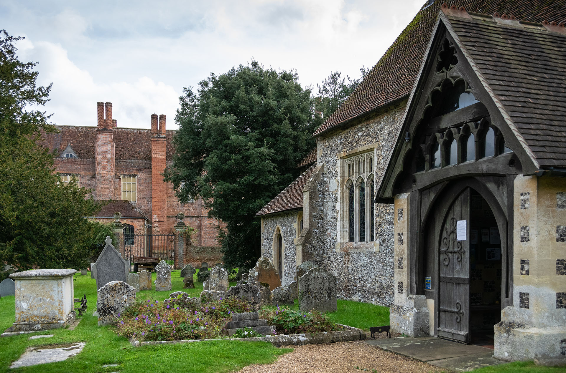 The remarkable site of Mapledurham village beside the Thames, with a mill, pretty stone and flint church, and an impressive Elizabethan manor house