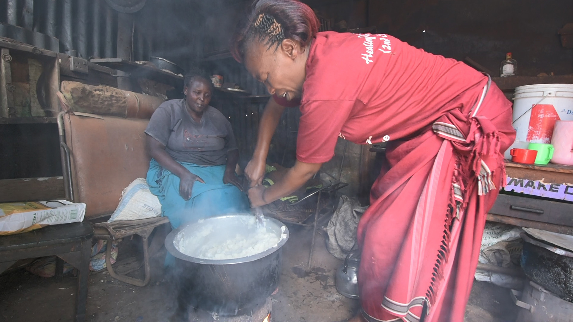 Women cooking Ugali on wood stove in Kenya