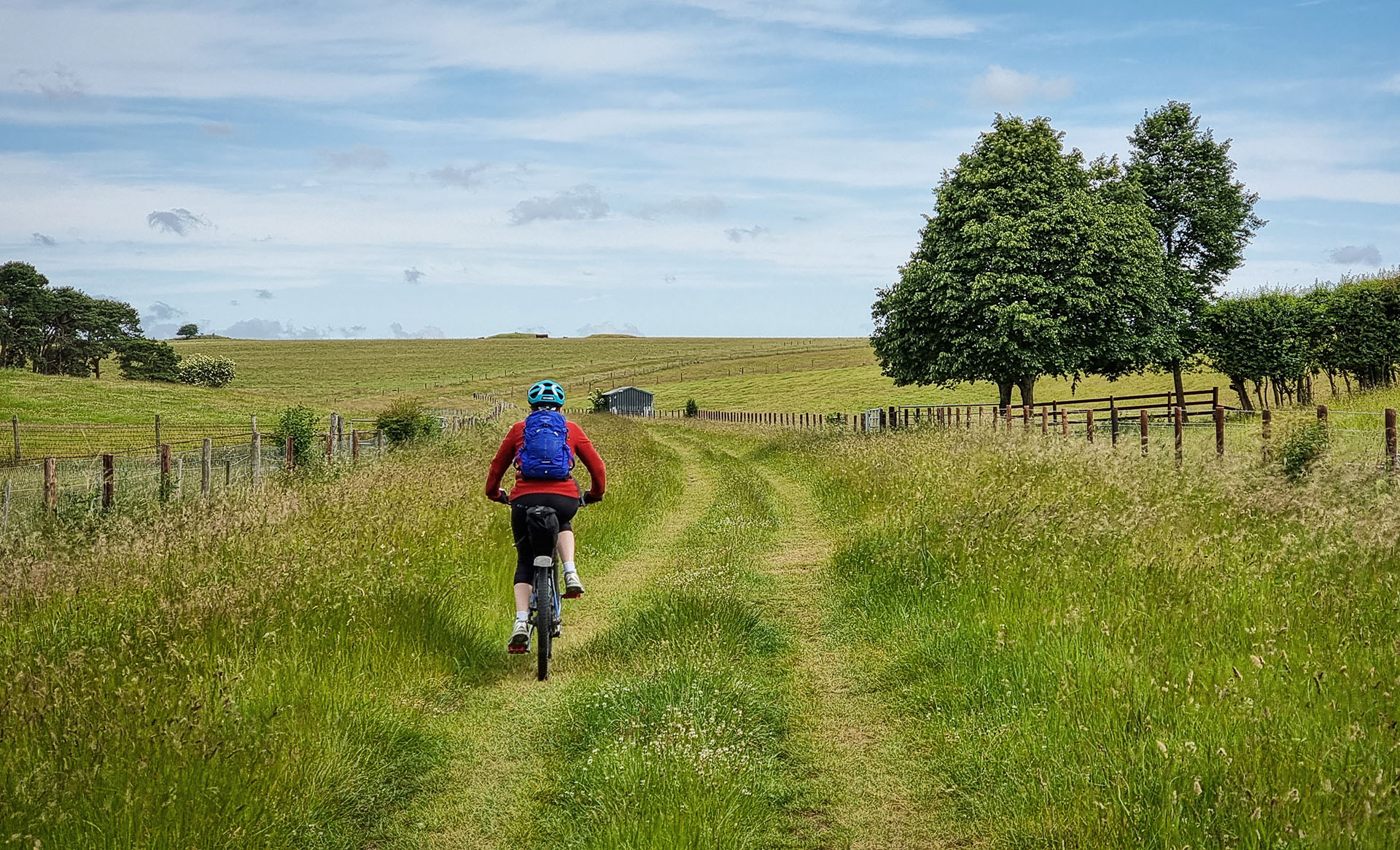 Riding up Springbottom Valley towards large tumuli on the horizon, with Stonehenge just beyond